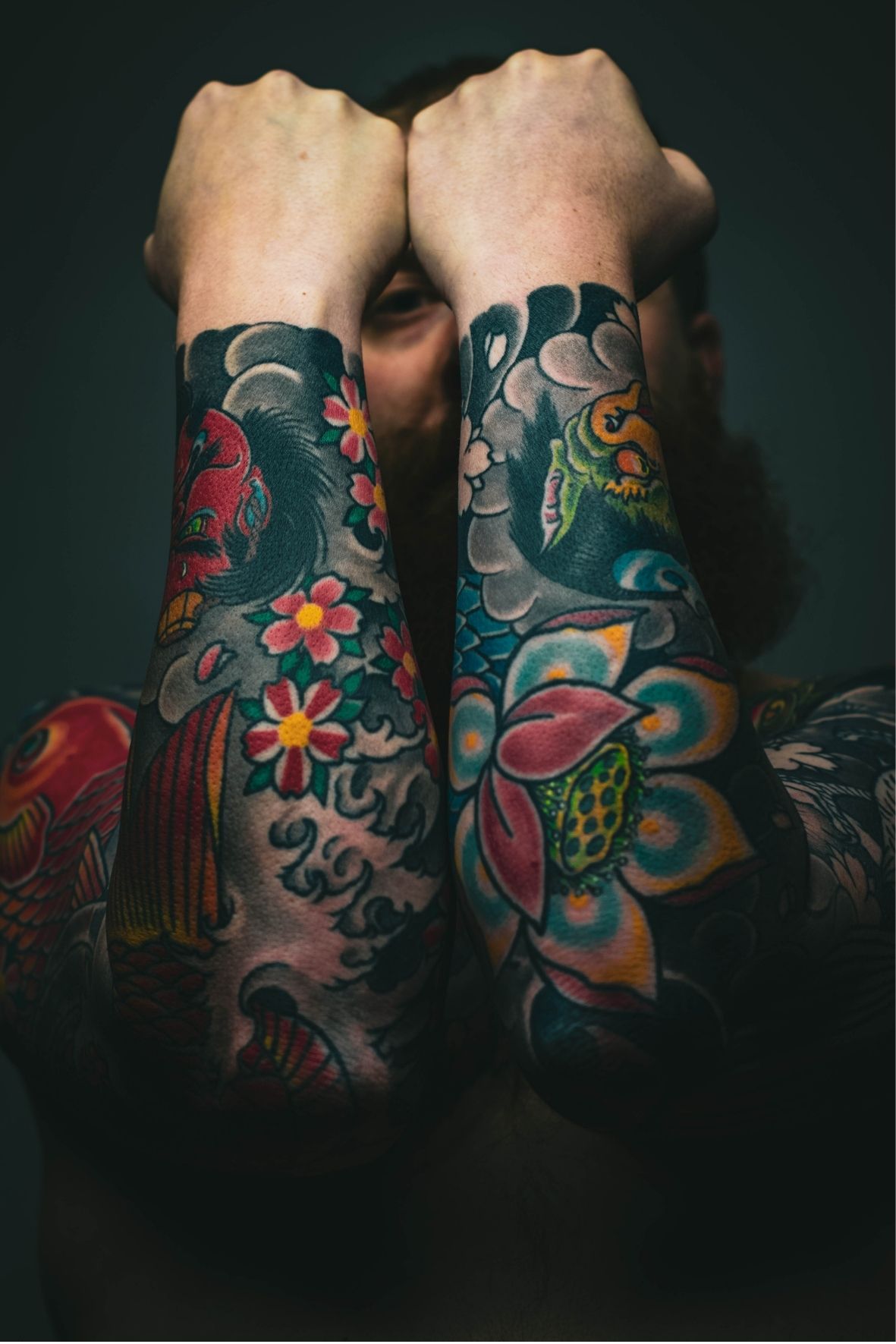 Avant-bras entièrement couverts de tatouages colorés avec motifs floraux et illustratifs à Berthierville