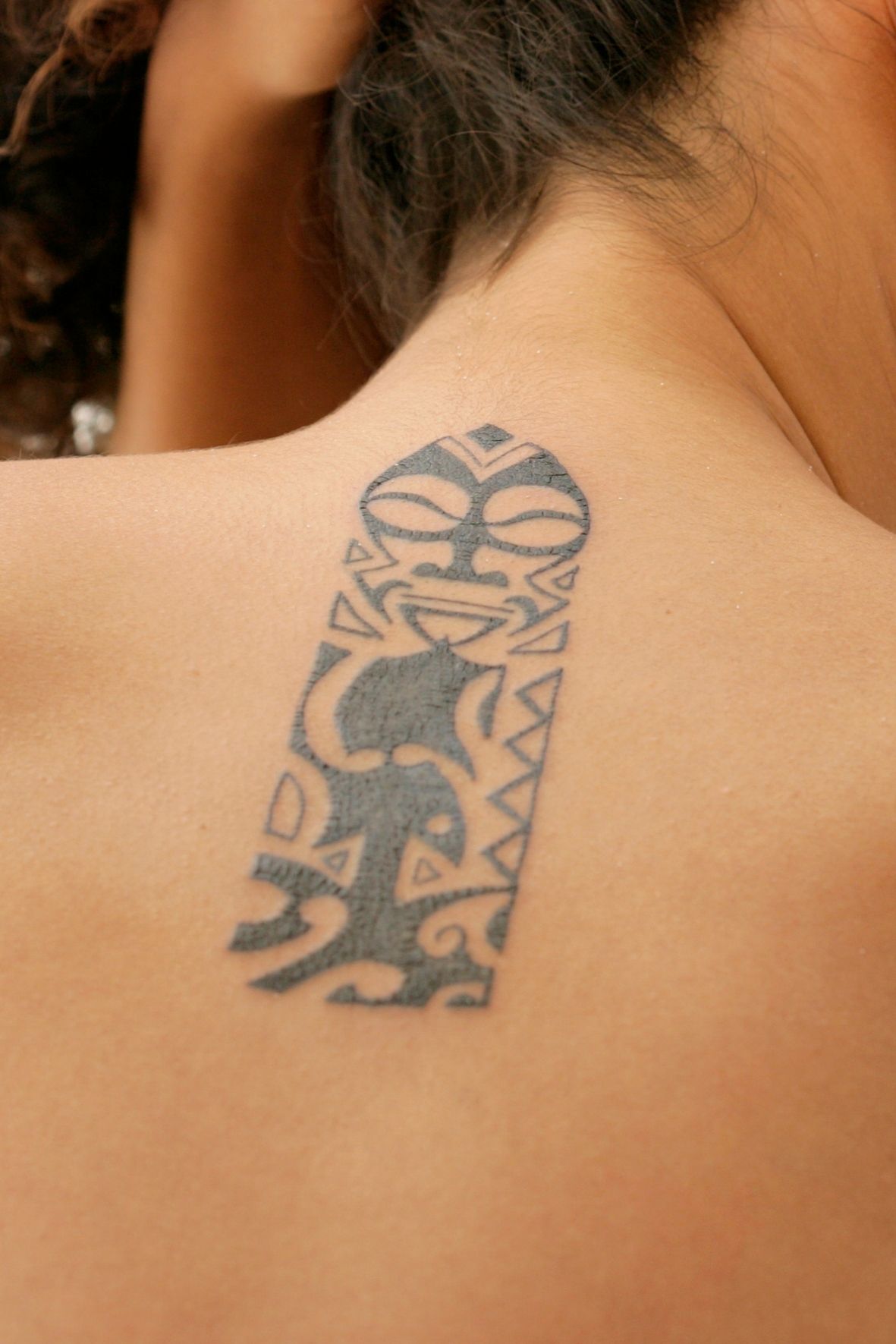 Tatouage noir avec motifs tribaux visible sur la nuque d’une personne dans l’univers du tatouage  dans les Laurentides